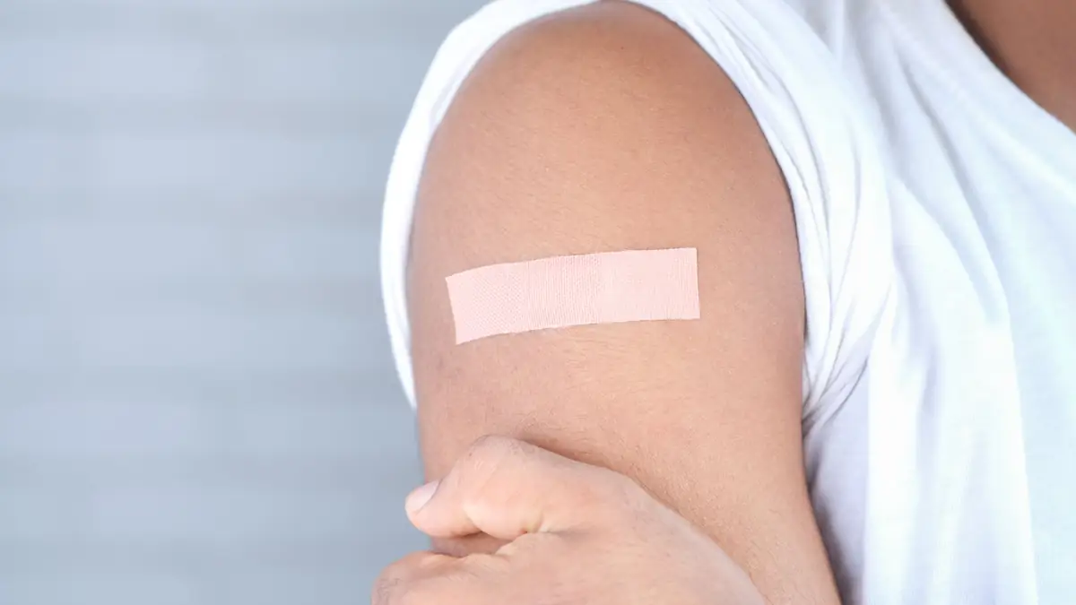 Small adhesive bandage on an upper arm after a blood draw