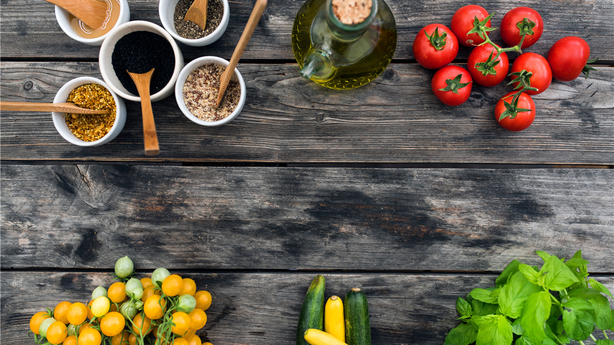 Wooden table with fresh vegetables, tomatoes, nuts, and salmon representing prostate-friendly foods