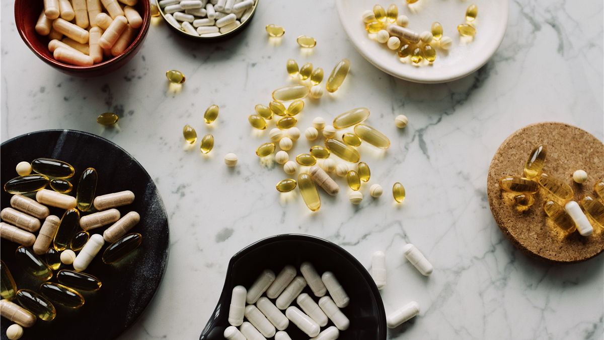 Several unlabeled supplement capsules arranged in a row on a table, representing a side-by-side comparison