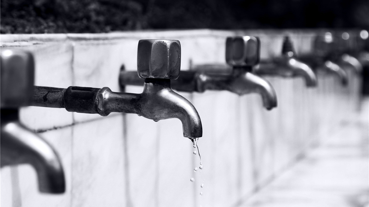 Bathroom faucet with a thin trickle of water representing a weak urinary stream