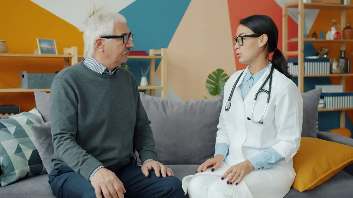 Older man talking with a doctor during an appointment in a bright office