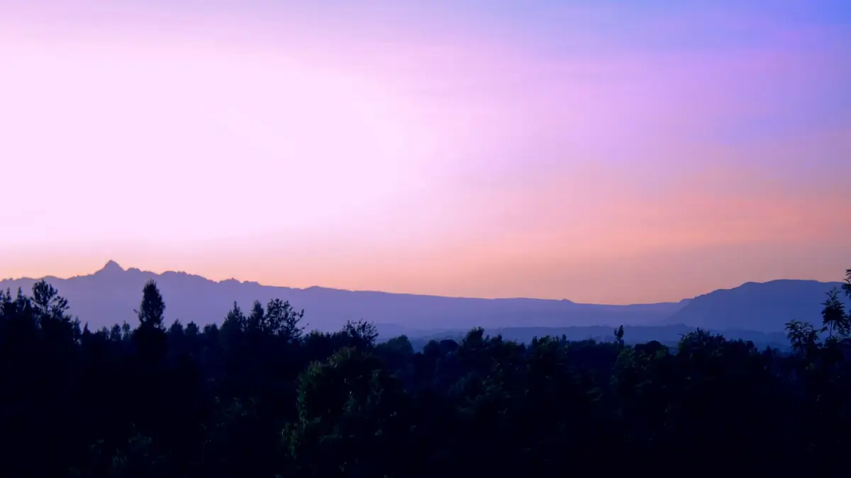 Mount Kenya at dusk above the forested hills of Meru County, Kenya